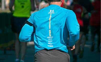 The backside of a person in running clothes running in a marathon
